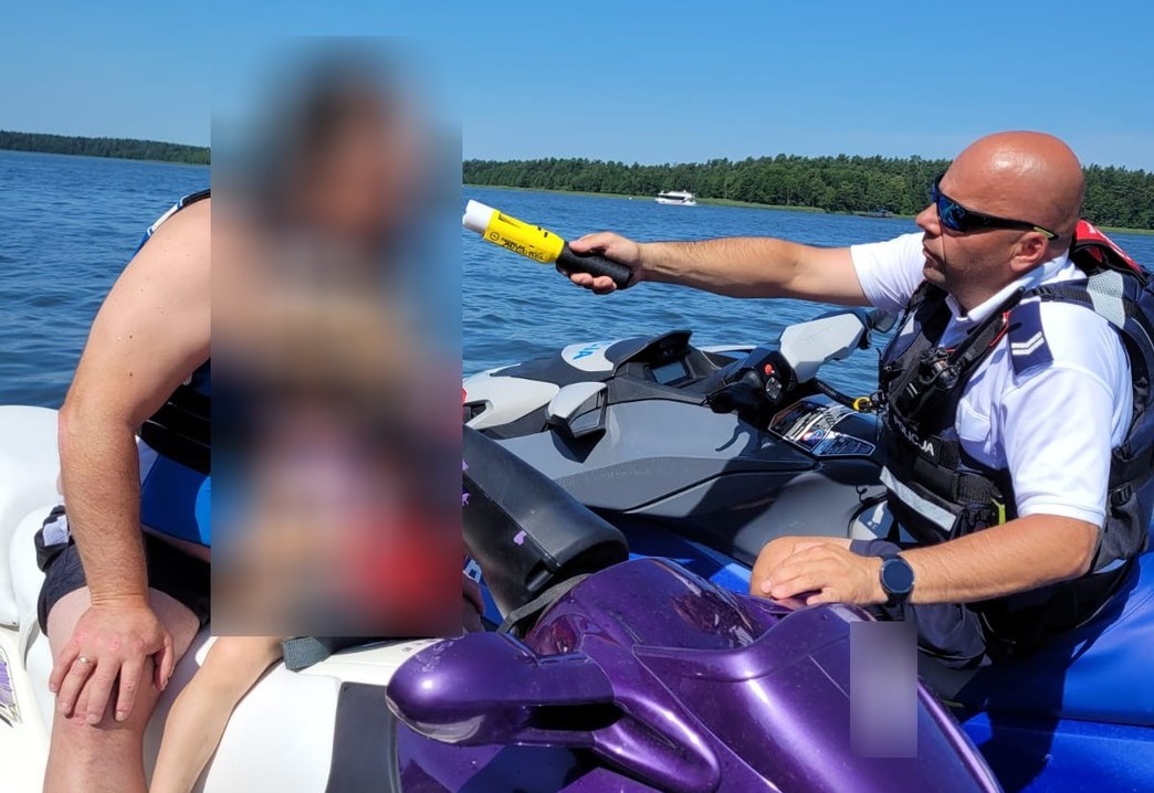 Policjant kontroluje trzeźwość kierowcę skutera wodnego