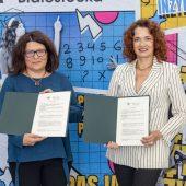 Dwie kobiety trzymają otwarte teczki z dokumentem