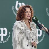 Elegancka kobieta mówi do mikrofonu na statywie i mikrofonów trzymanych w ręku
