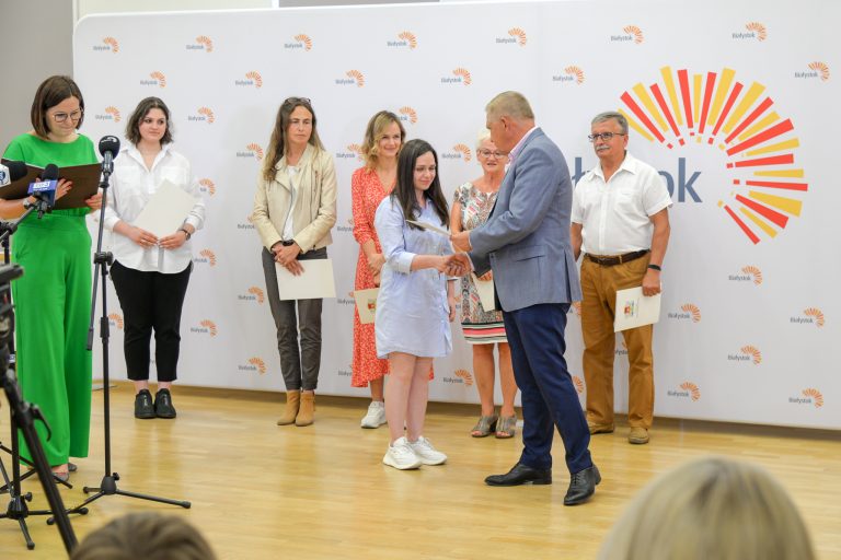 mężczyzna daje dyplomy kilku osobom