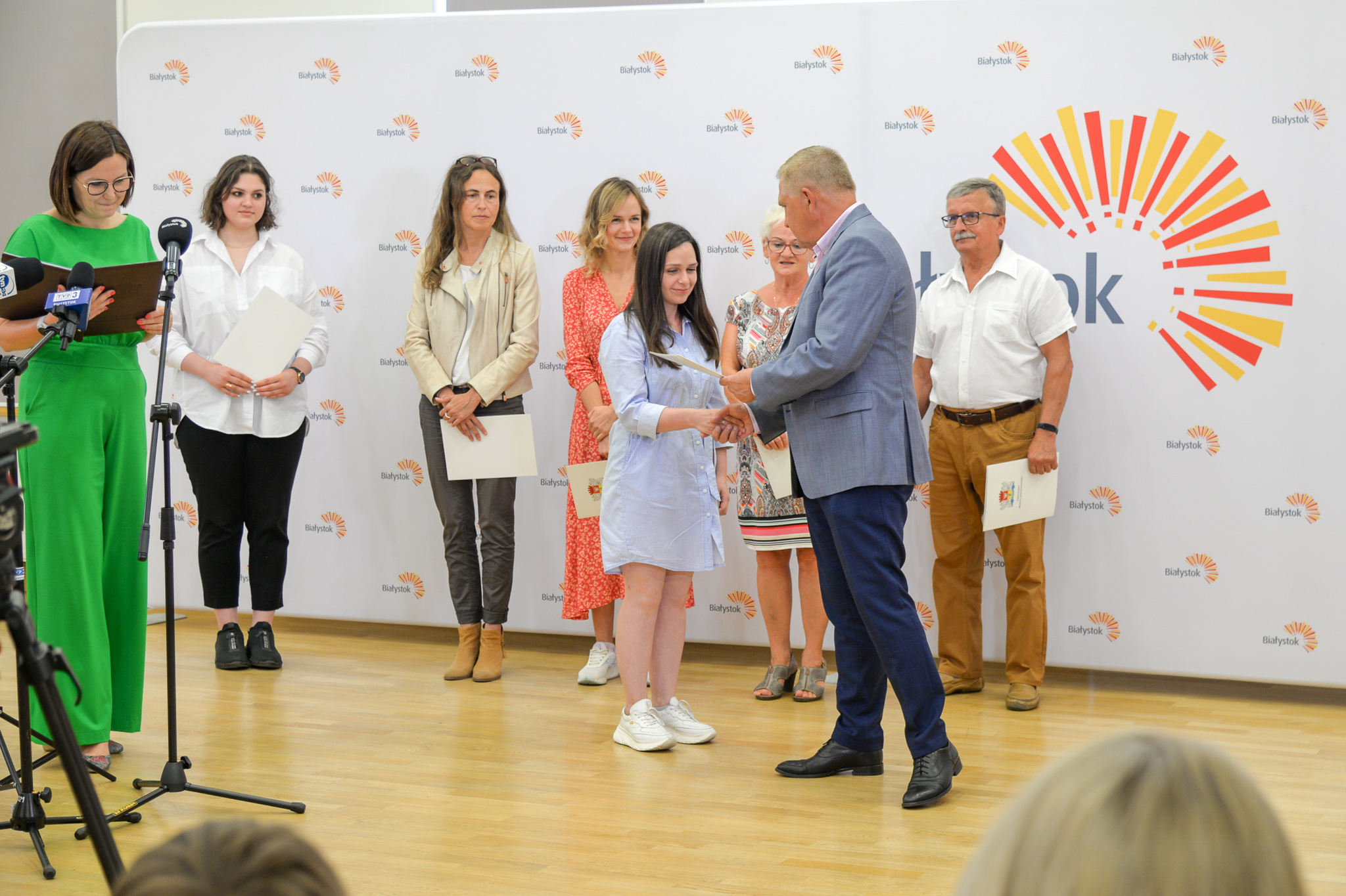 mężczyzna daje dyplomy kilku osobom