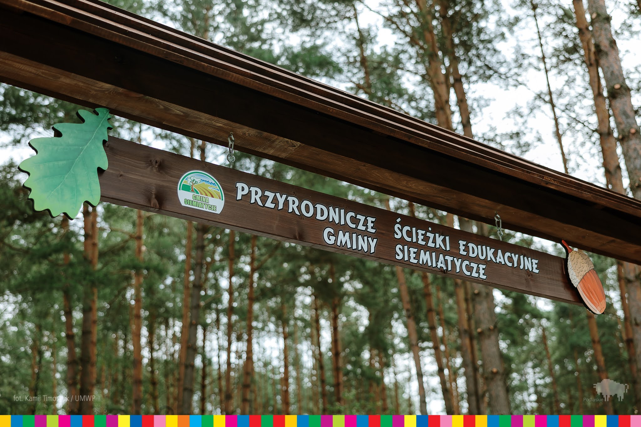 drewniana zawieszka nad wejściem z napisem "Przyrodnicze ścieżki edukacyjne gminy Siemiatycze"