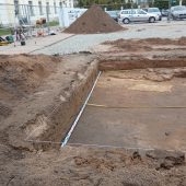 Ogrodzony wykop archeologiczny na parkingu