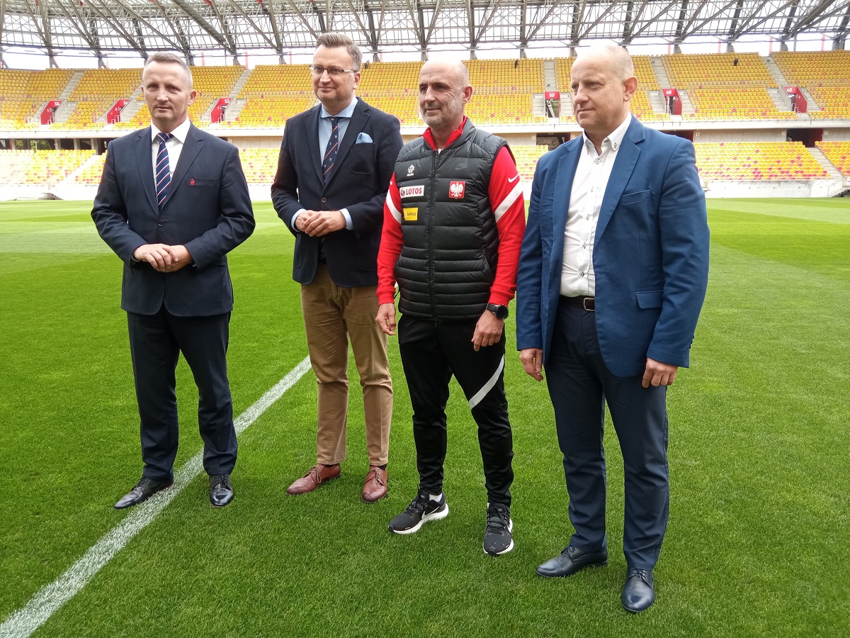 Czterech mężczyzn stoi na murawie stadionu