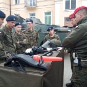 Młodzież w wojskowych mundurach ogląda sprzęt. Obok stoją żołnierze Wydziału Żandarmerii Wojskowej w Białymstoku