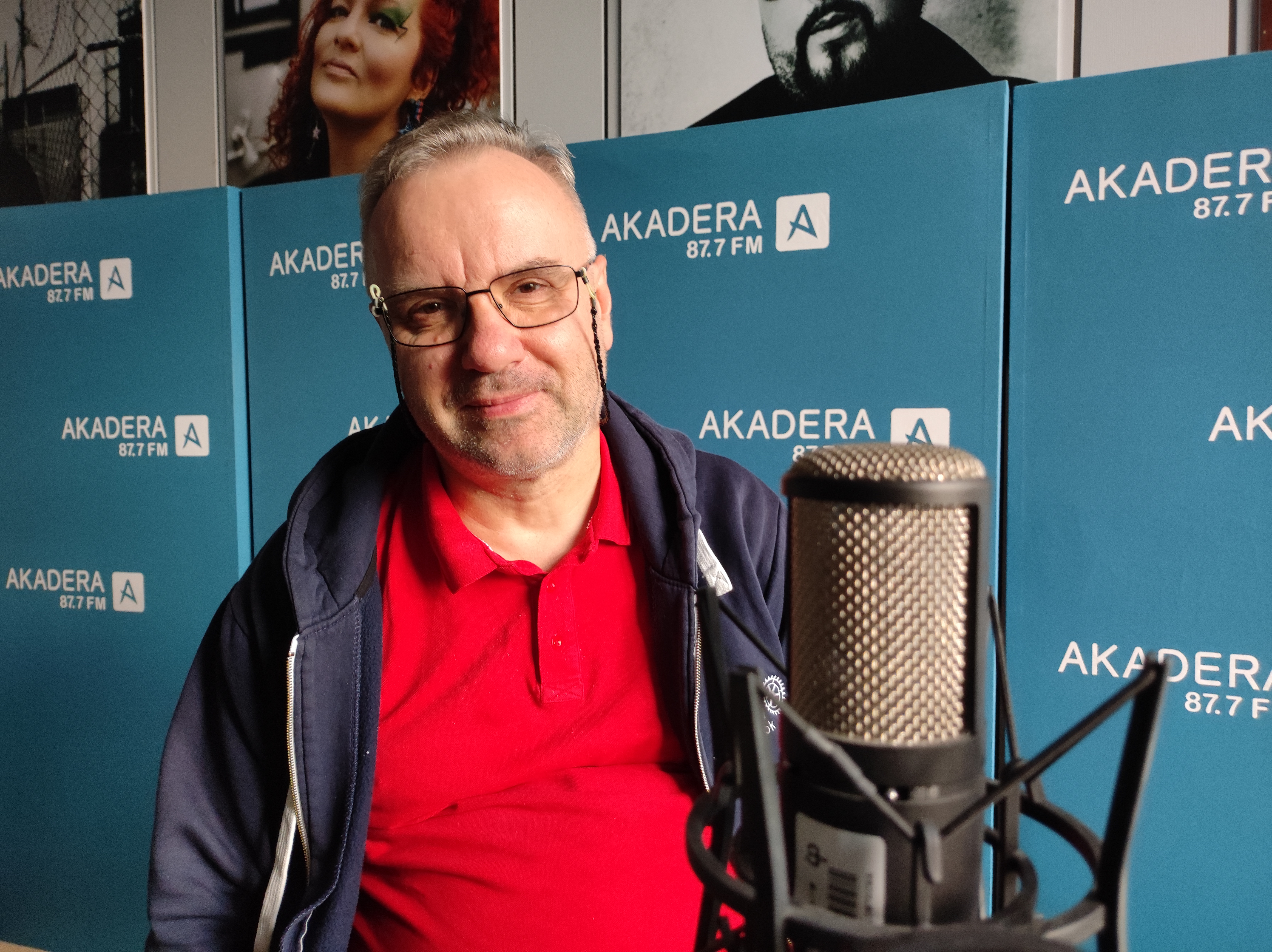 Mężczyzna w okularach siedzi w studiu radiowym