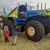 Auto typu monster truck, a obok dzieci