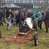 Auto typu bolid na trawie, a dookoła dużo ludzi