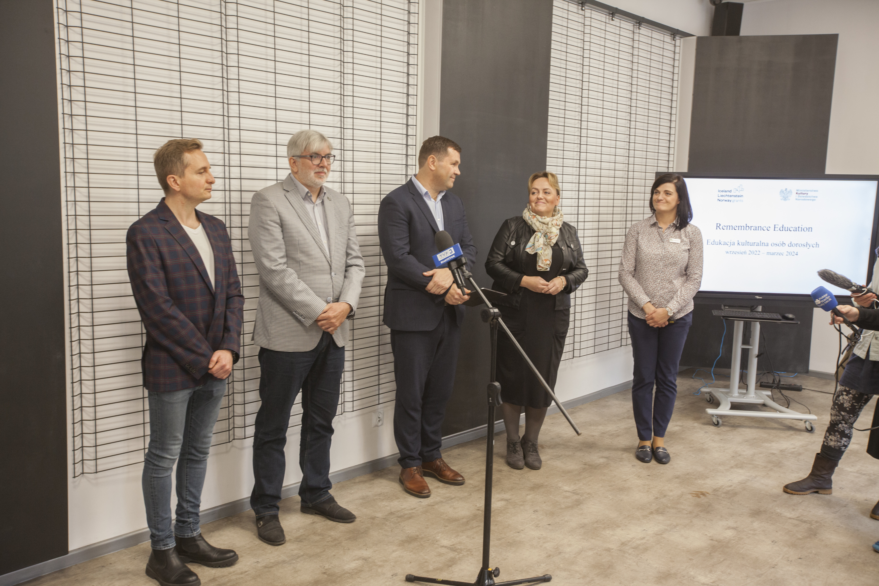 Pięc osób stoi przed mikrofonami podczas konferencji prasowej