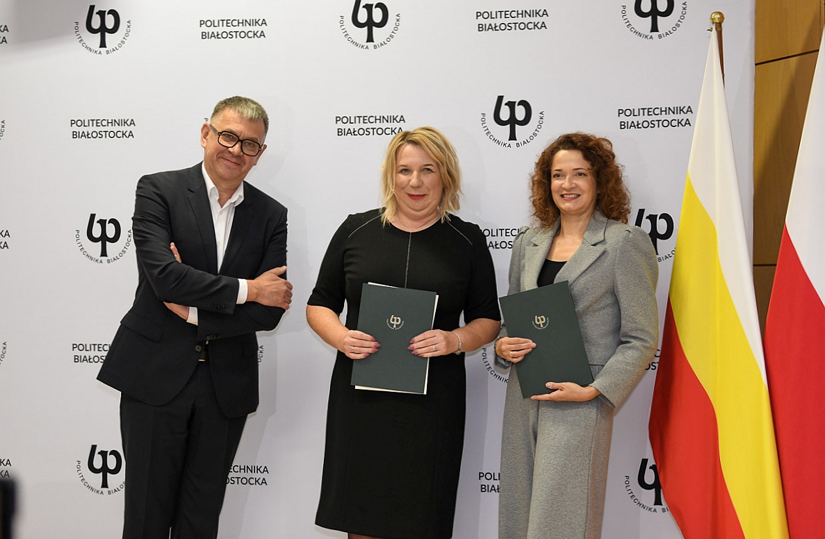 Dwie leganckie kobiety i meżczyzna pozują dozdjęcia trzymając teczki