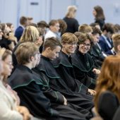 Grupa uczniów siedzi na sali w oczekiwaniu na przyznanie stypendiów