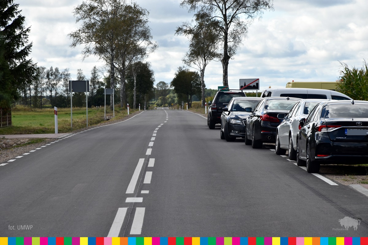 Droga wojewódzka, na poboczu stoją zaparkowane samochody