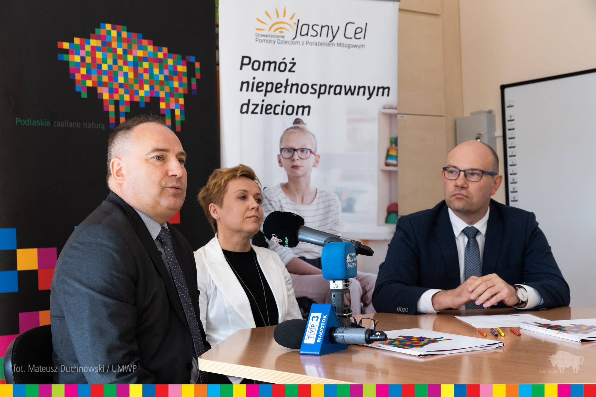Trzy osoby siedzą przy stole