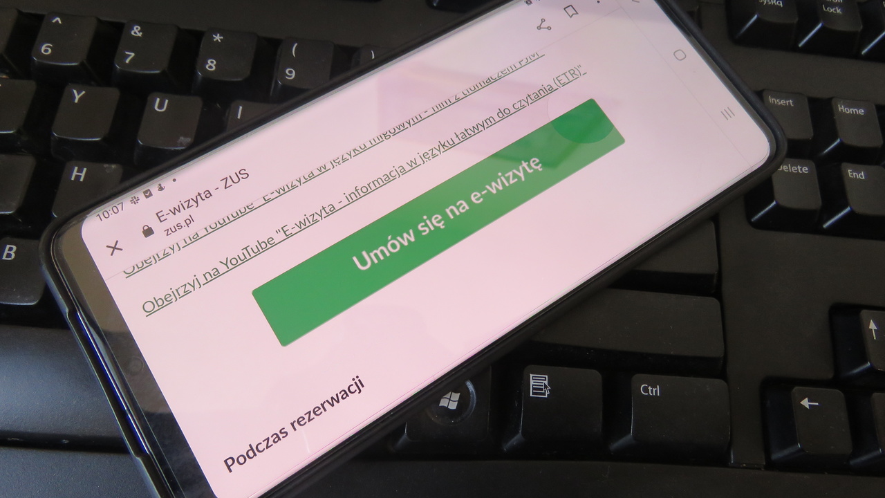 zielony przycisk "umów wizytę" widoczny na telefonie komórkowym