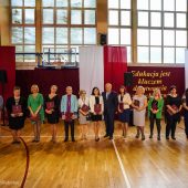 Kilkanaście nagrodzonych oób stoi obok siebie na sali