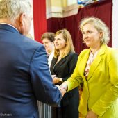 Mężczyzna gratulując ściska rękę kobiecie