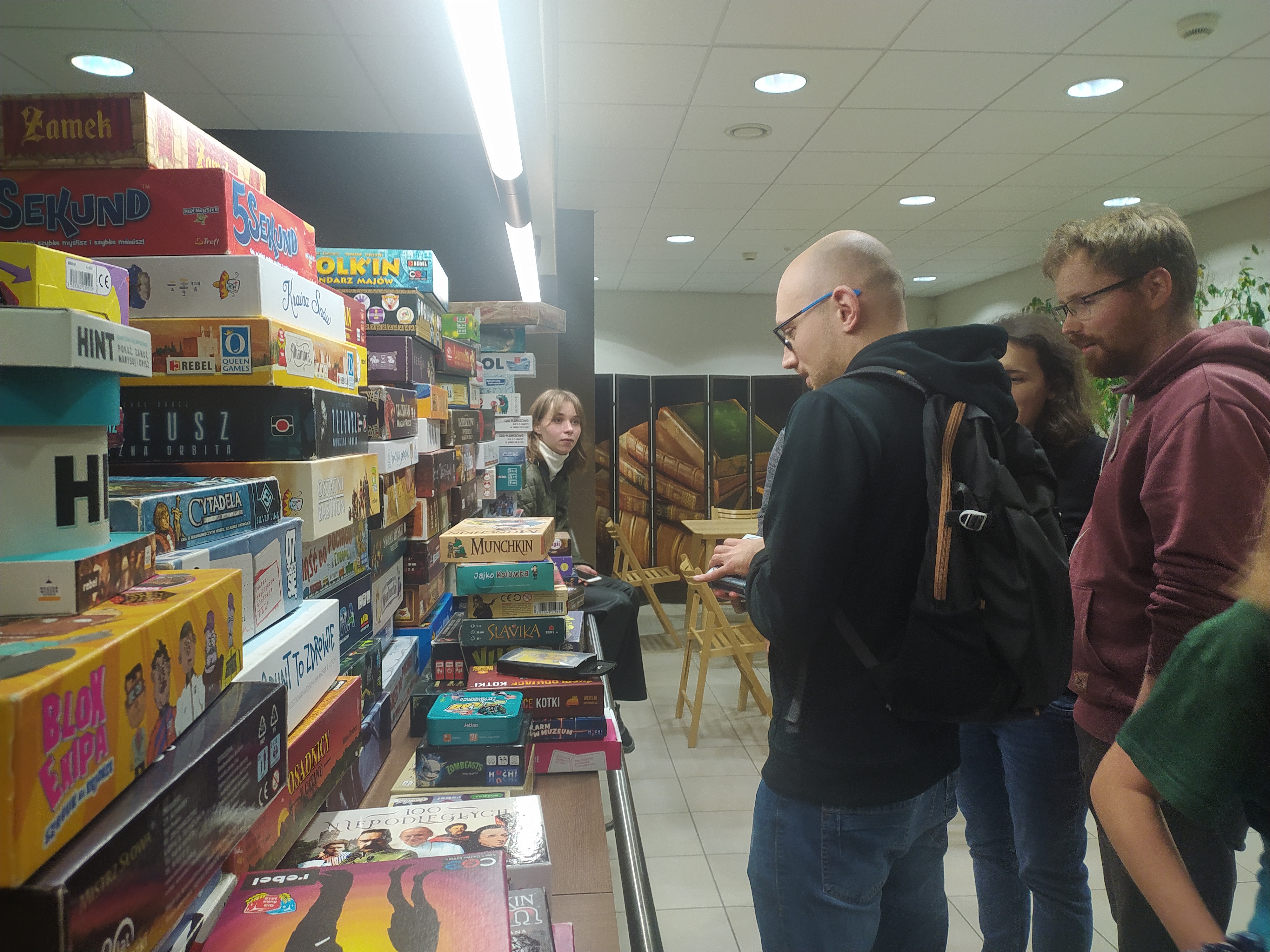 Trzech mężczyzn patrzy na gry planszowe
