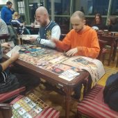 Ludzie siedzą przy stolikach i grają w gry planszowe