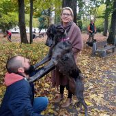 Olbrzymi pies - dog opiera się łamapami na ramionach męźczyzny. Obok stoi kobieta