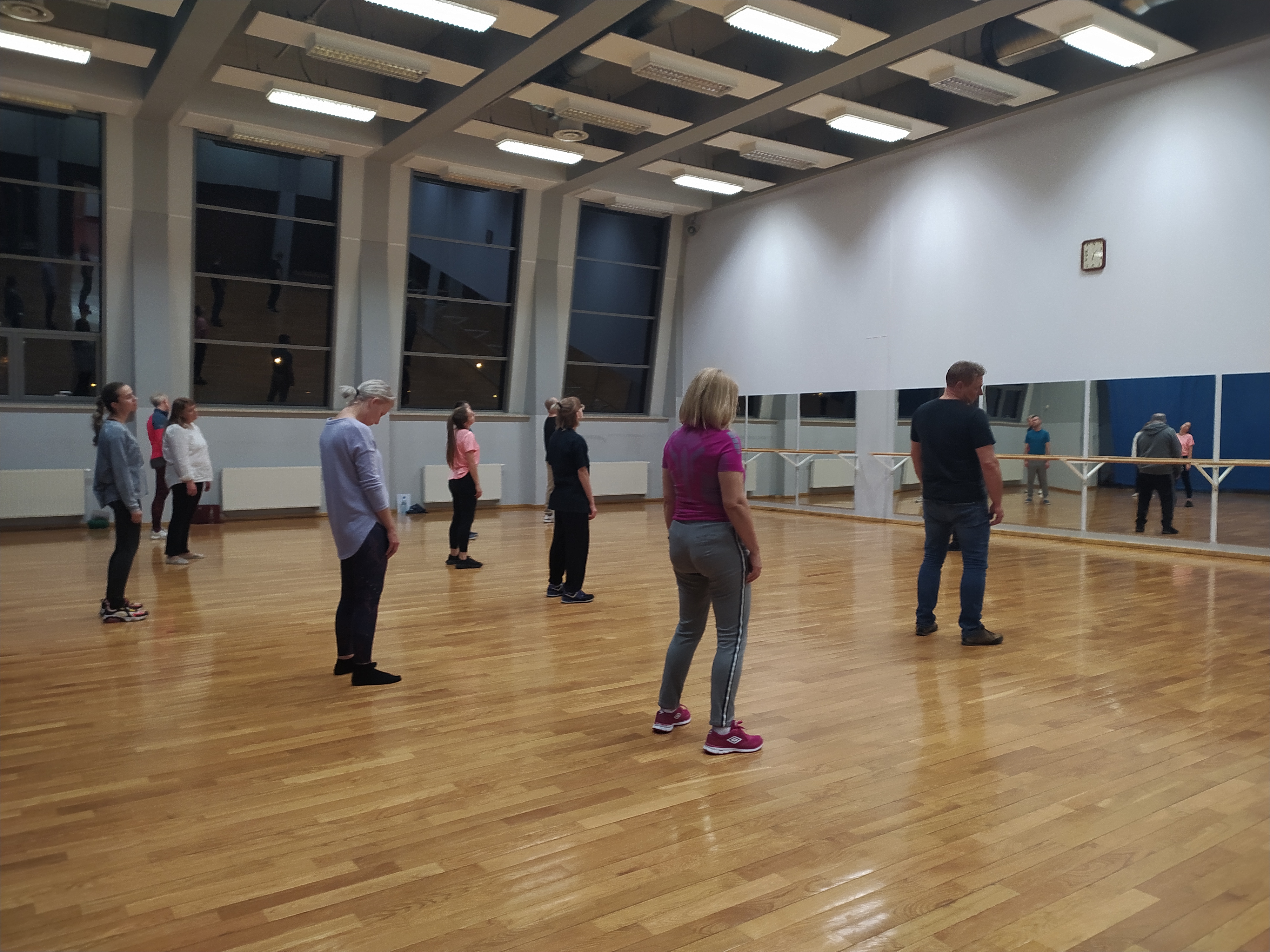Kilkanaście osób stoi na sali sportowej