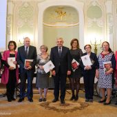 Grupa osób stoi z duplomami obok prezydenta miasta