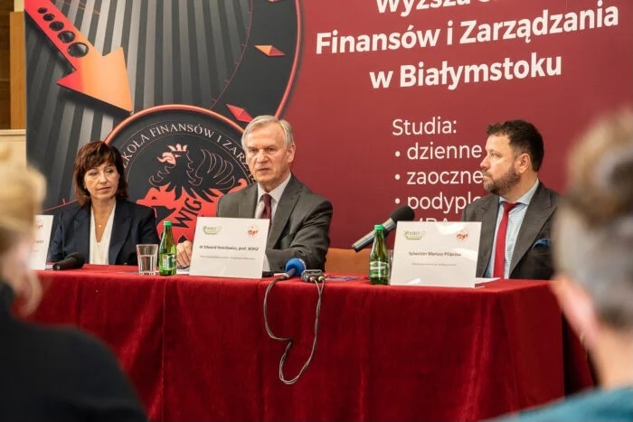 Trzy osoby siedzą przy stole