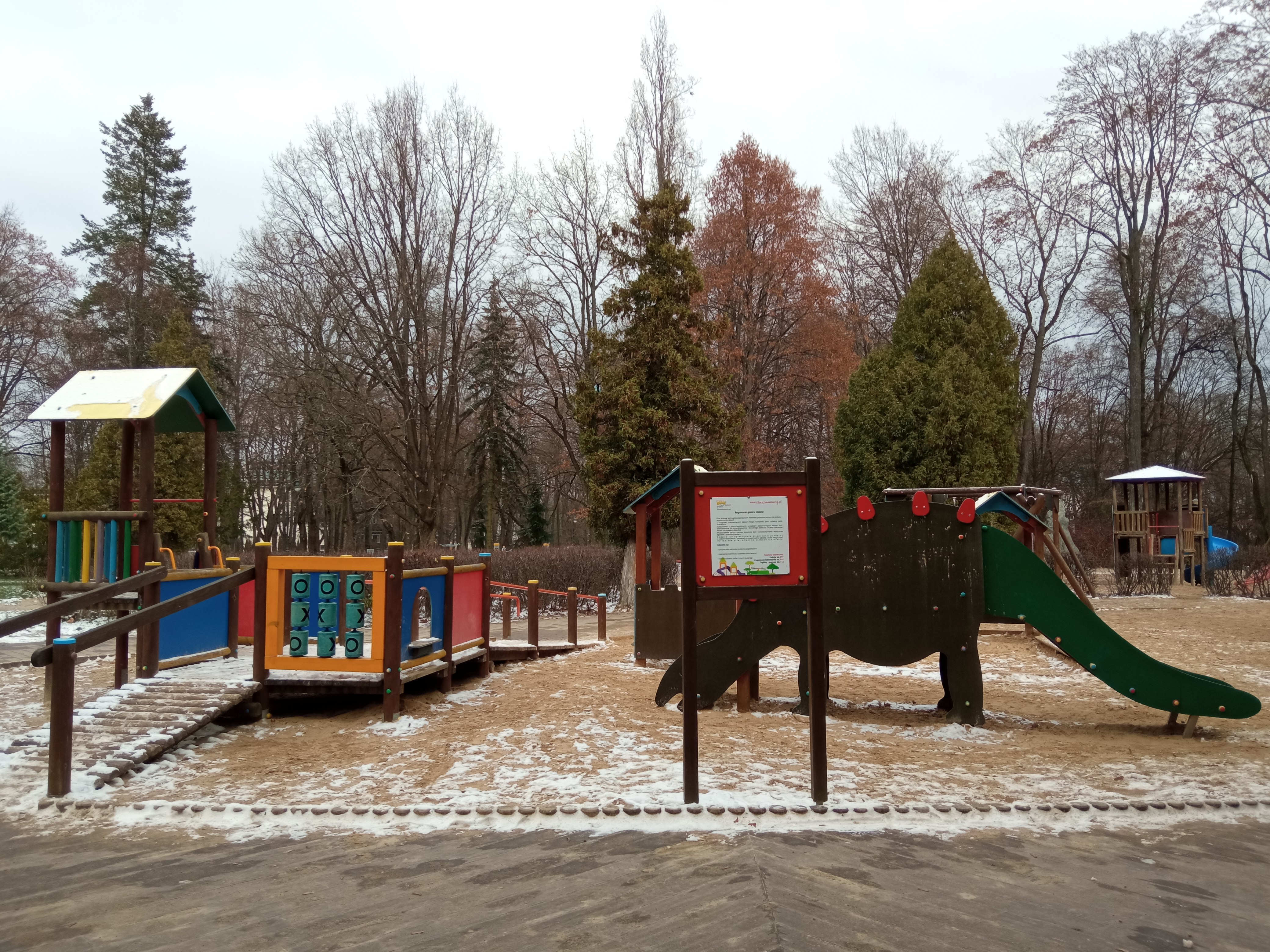 Wejscie na plac zabaw, w tle drewniane elementy konstrukcjiy