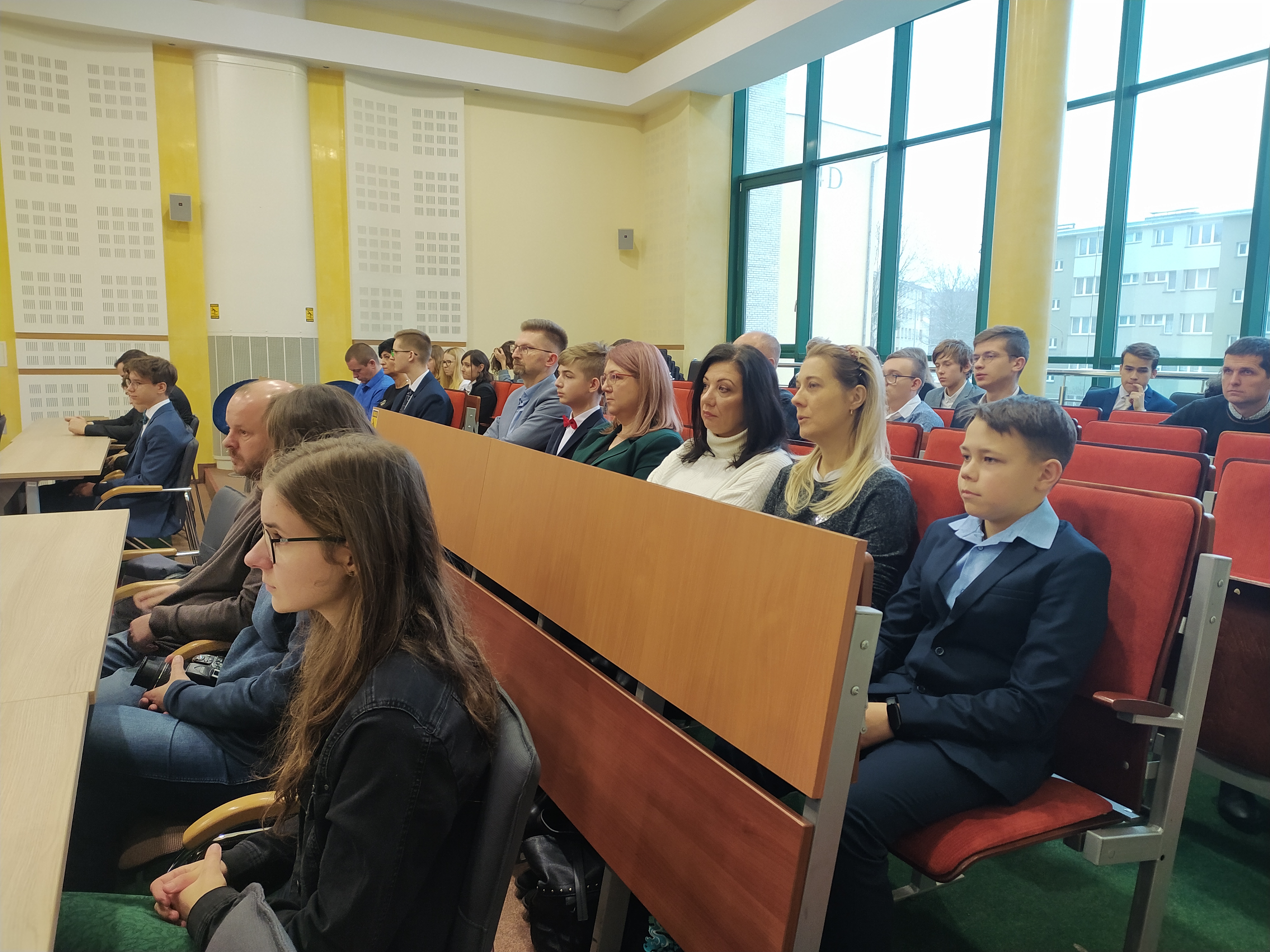 Kilkadziesiąt młodych ludzi siedzi w sali konferencyjnej