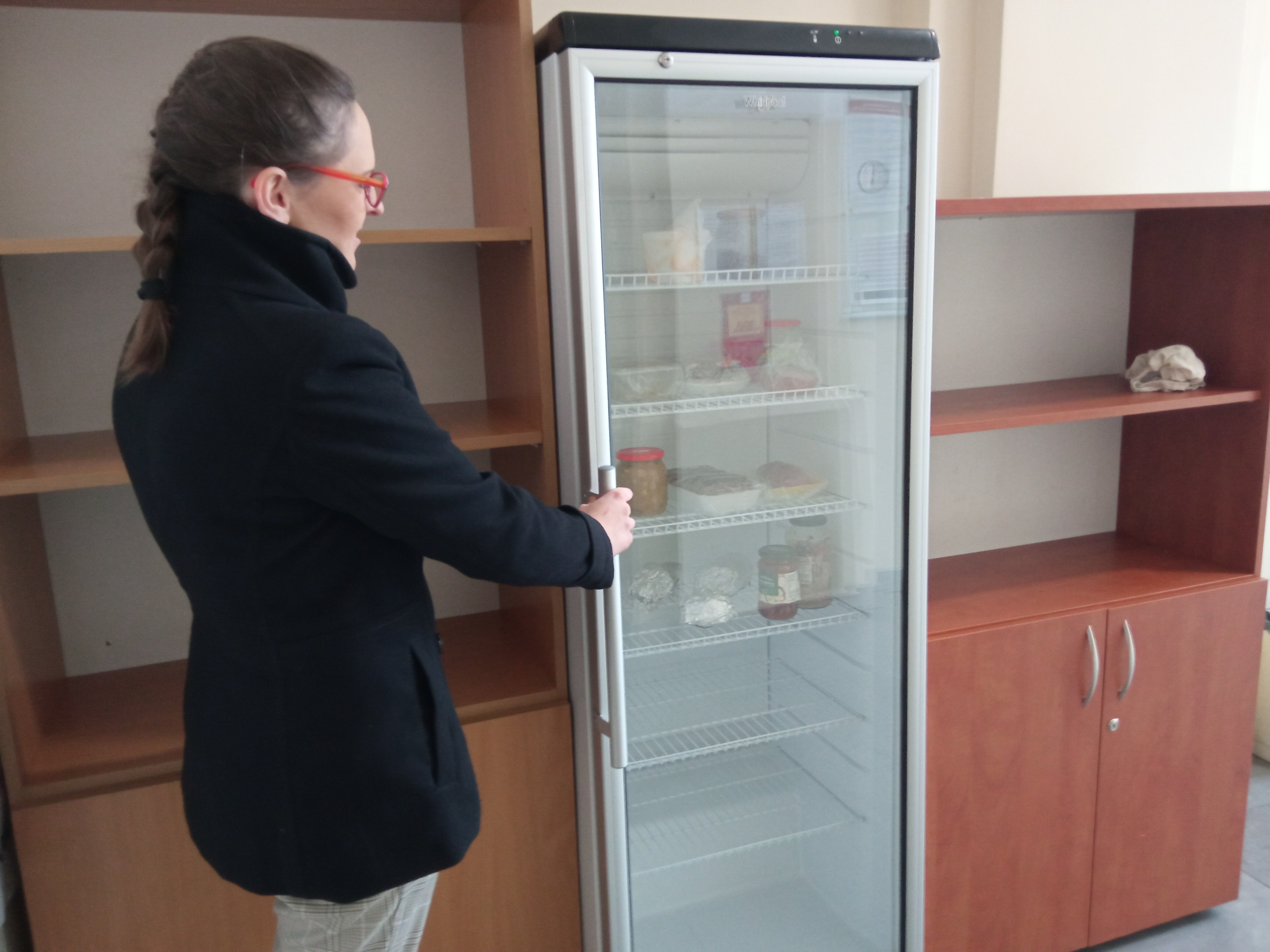 Kobieta otwiera lodówkę w jadłodzielni