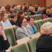 Grupa osób siedzi na auli