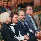 Grupa osób siedzi na auli