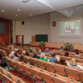 Grupa osób siedzi na auli ogląda prezentacje