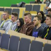 Ludzie na auli na pierwszym planie siedzą finaliści konkursu