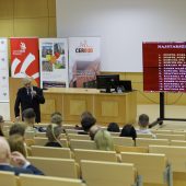 Ludzie na auli słuchają wykładu starszego mężczyzny