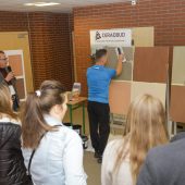 Grupa ludzi obserwuje pokaz tynkowania