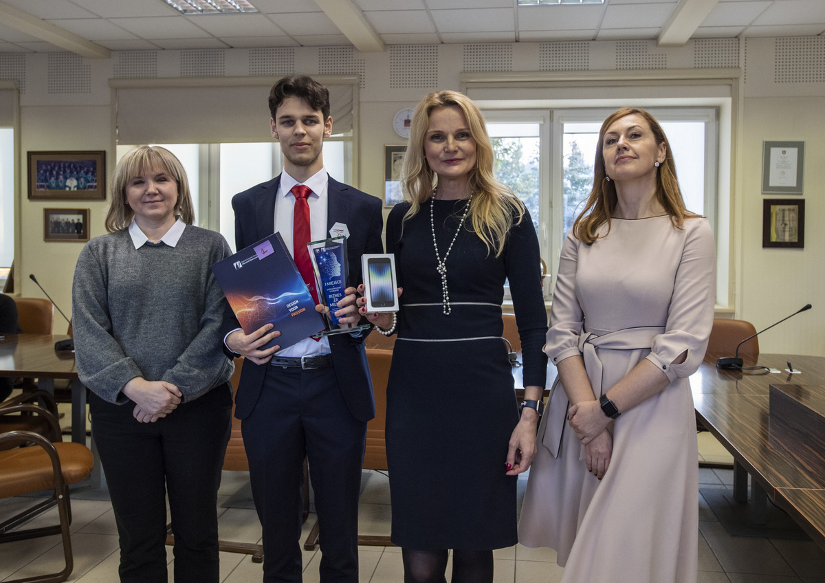 aureat stoi z nagroda, obok panie z jury