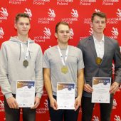 trezch młodych mężczyzn stoi z nagrodami i medalami