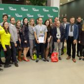Grupa osób stoi wokół zwycięzcy