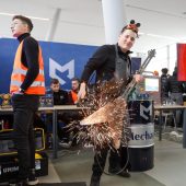 Uczeń podaczas prezentacji szkoły gra na metalowej gitarze