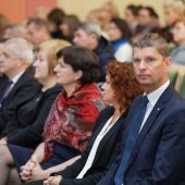 Grup aosób siedzi na auli