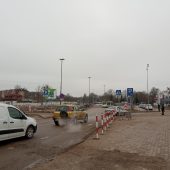 Samochody jadą roboczymi drogami obok dworca PKS