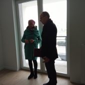 Wewnątrz w nowym mieszkaniu przy oknie stoi kobieta i mężczyzna
