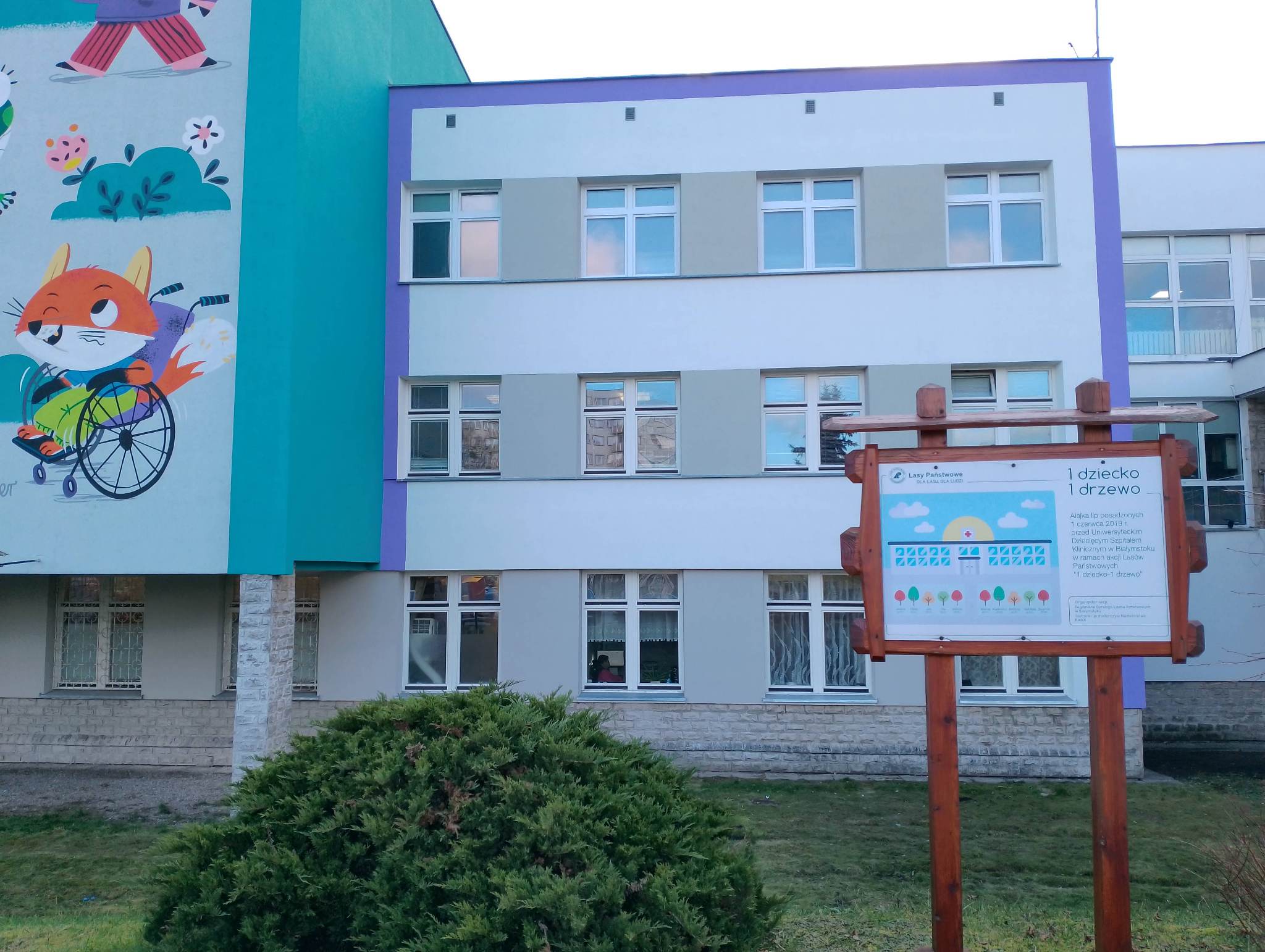 Ściana szpitala w nowej kolorystyce, obok fragment muralu