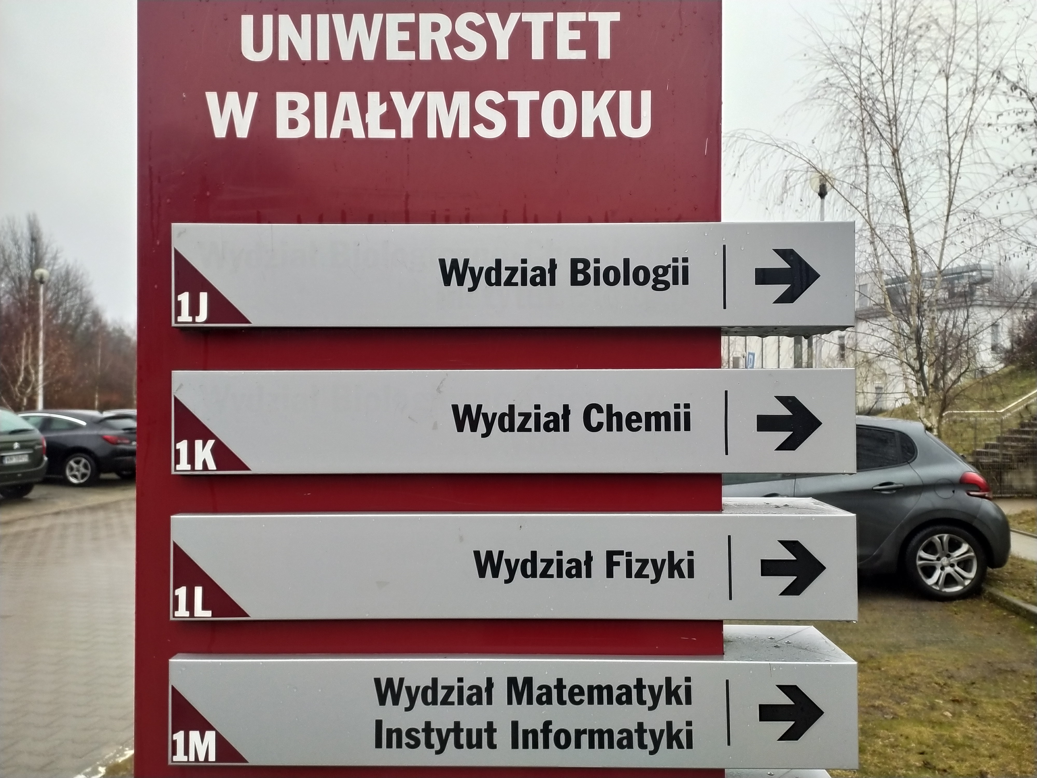 Zewnętrzny totem wskazujący strzałkami drogę na wydziały