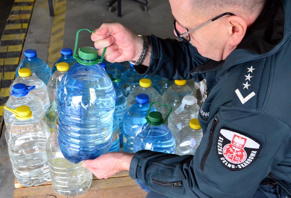 Funkcjonariusz KAS przy butelkach z alkoholem