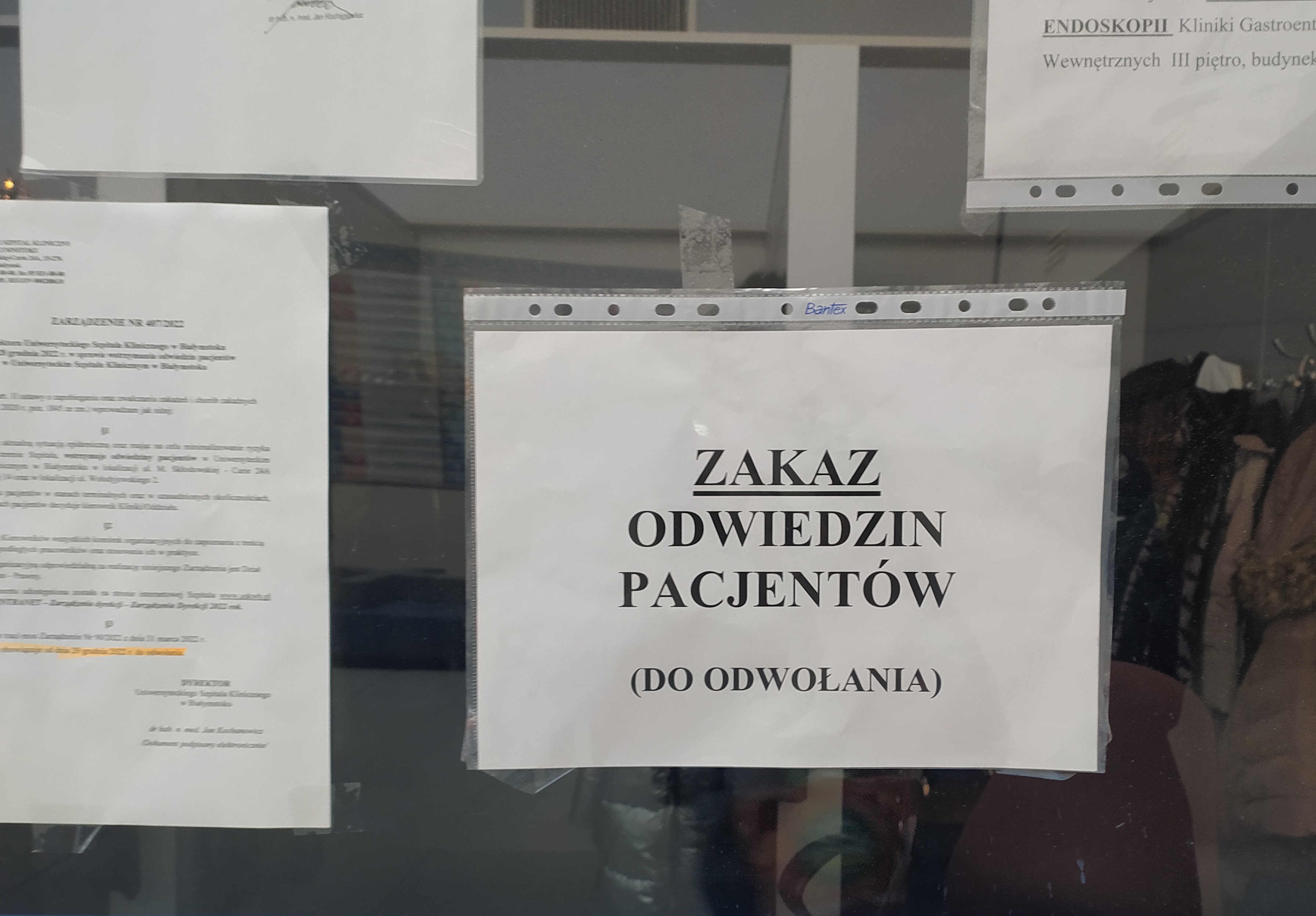 Kartka z napisem "Zakaz odwiedzin pacjentów (do odwołania) wisi na szybie