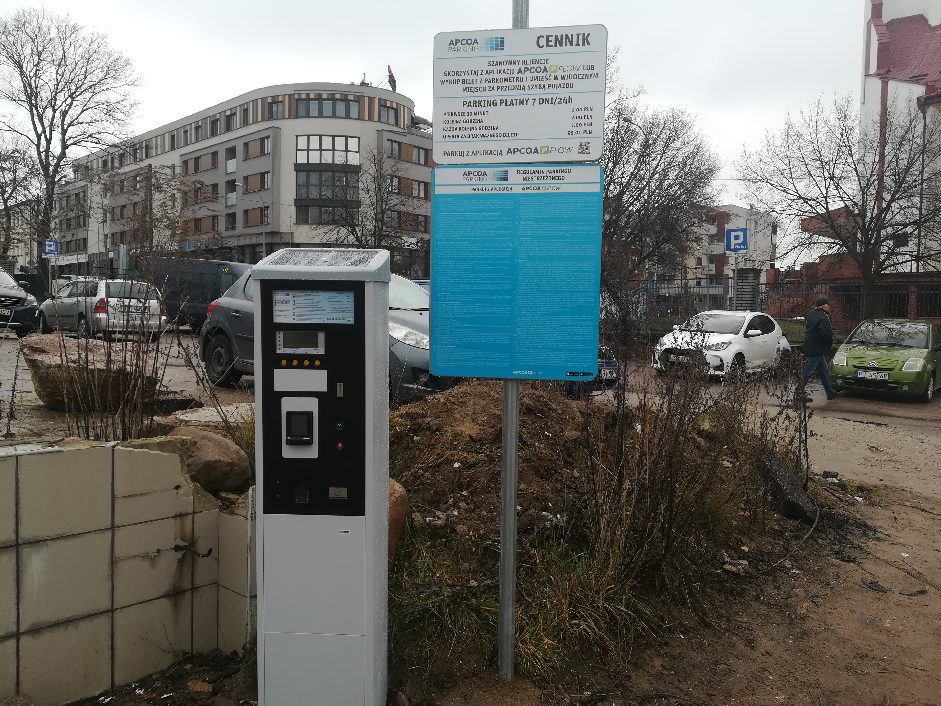 Parkometr i tablica informacyjna na parkingu