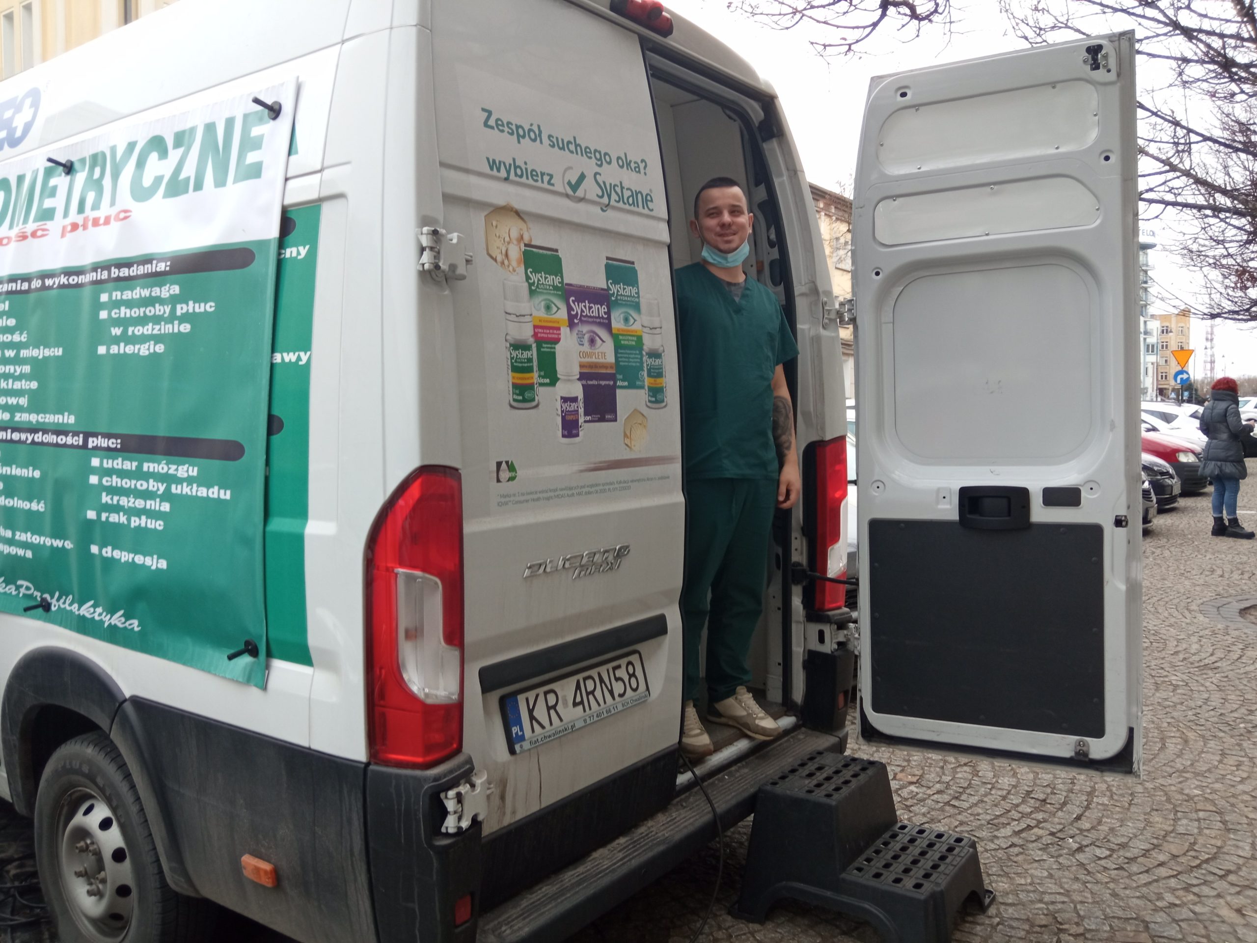Mężczyna stoi na schodkach busa