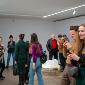 Ludzie oglądają wystawę w dużym pomieszczeniu