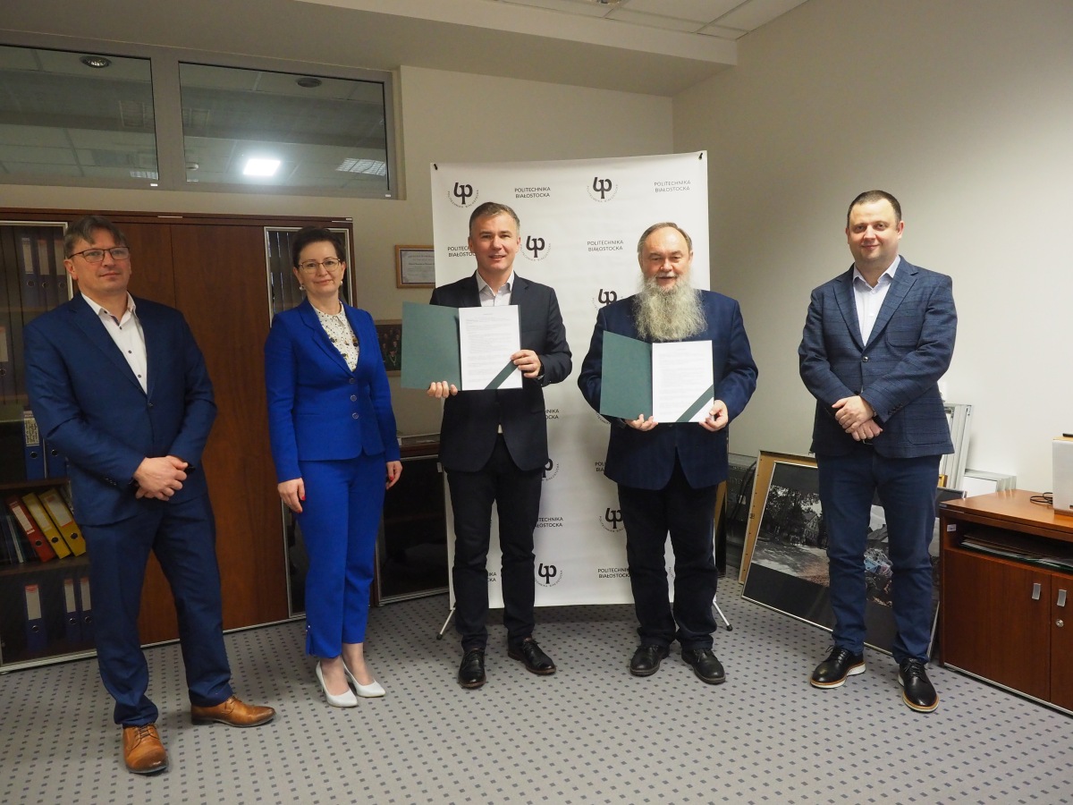 Pięc elegancko ubranych osób pozuje do zdjęcia trzymając teczki